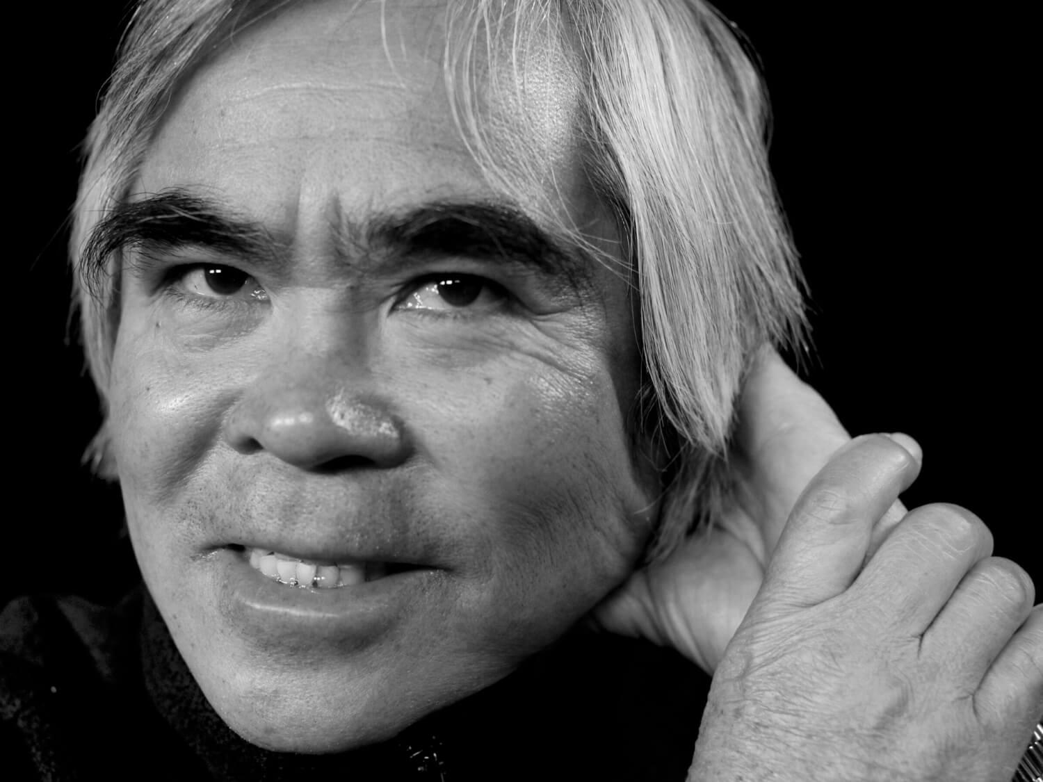 Close-up black-and-white portrait of photographer Nick Ut