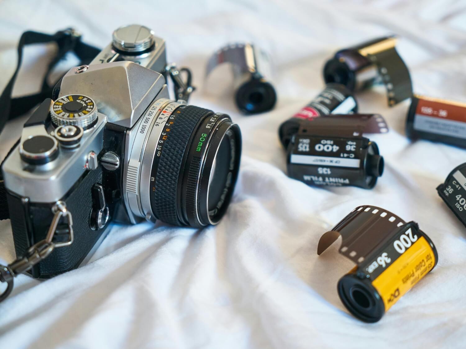 Analogue camera surrounded by rolls of film 